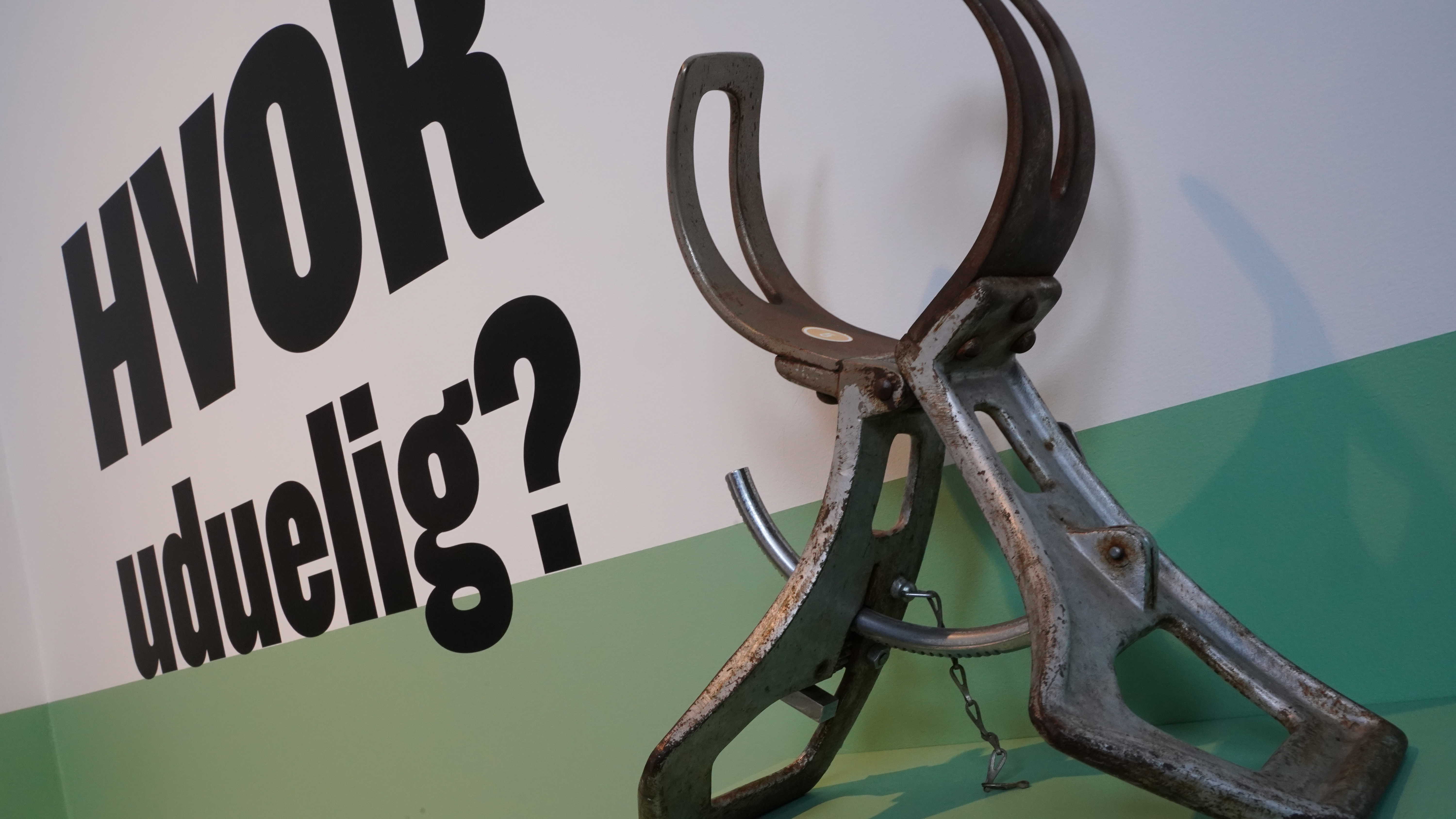 Foto af hovedmåler og skrift på væg: "Hvor uduelig?"