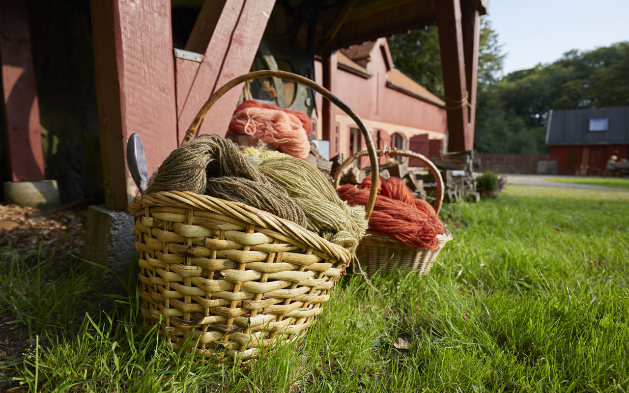 Kurve med håndfarvet garn foran Randbøldalmuseet